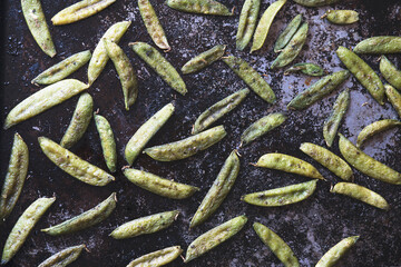 Roasted snow peas on black pan in natural light