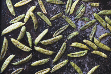 Roasted snow peas on black pan in natural light