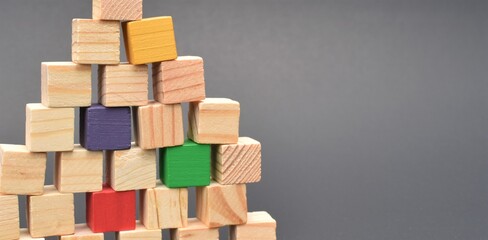 Pile of multicolored wooden blocks on black background. Shows diversity in the workplace, building together as a team of individuals. Room for copy.