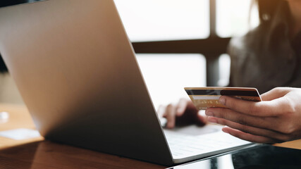 woman's hands holding smartphone and using credit card for online shopping.