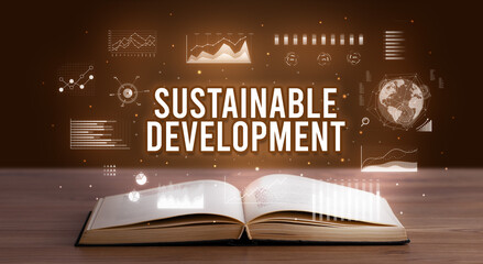 SUSTAINABLE DEVELOPMENT inscription coming out from an open book, creative business concept