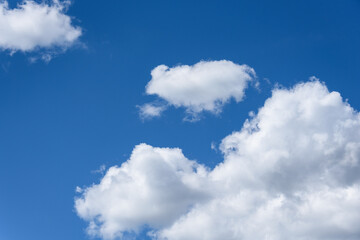 Naklejka na ściany i meble Bright blue sky with white puffy clouds, as a nature background 