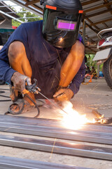 The welder is welding the various parts of the house construction.