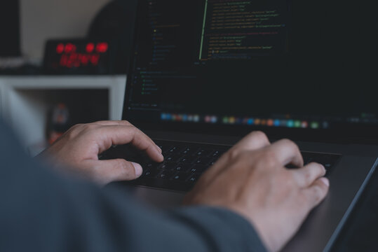 Programmer or software developer coding on laptop computer