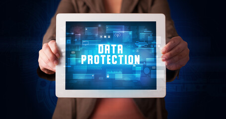 Young business person working on tablet and shows the digital sign: DATA PROTECTION