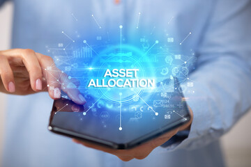 Businessman holding a foldable smartphone with ASSET ALLOCATION inscription, new business concept