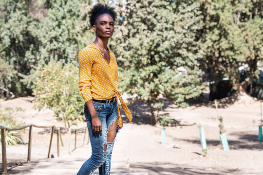 Portrait Young Black Woman In Yellow Shirt In The Middle Of Nature In A Park