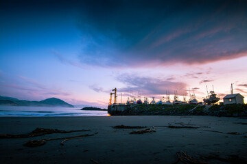 Fototapeta premium Sunset over boats moored in harbor in Port Orford. 