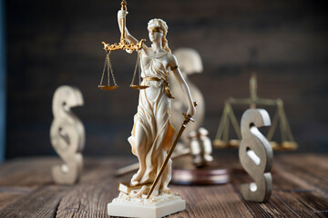 Law symbols composition. Themis statue, judge’s gavel and scale of justice on rustic wooden desk.