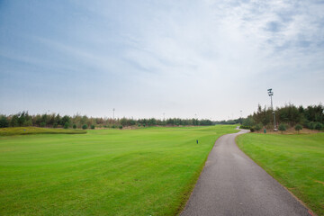 Naklejka premium Curvy pathway between meadows in golf course