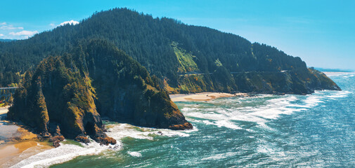 Aerial of Pacific Ocean in Oregon, Highway 101 winding through mountains. 