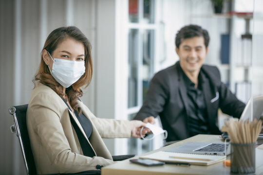 Business woman to share face mask with workmate for protect coronavirus covid-19 pandemic. Social and business distancing new normal lifestyle.