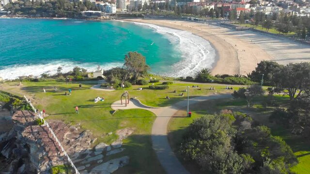 4k Drone shot over Coogee, Sydney. People, Beach, Streets, Dog Park, Ocean Waves crashing over rocks and more.