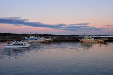 Fototapeta na wymiar 夕陽に染まる茅ヶ崎港に停泊する漁船