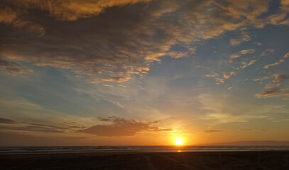 Fototapeta na wymiar Dramatic sunset at Oretti beach New Zealand