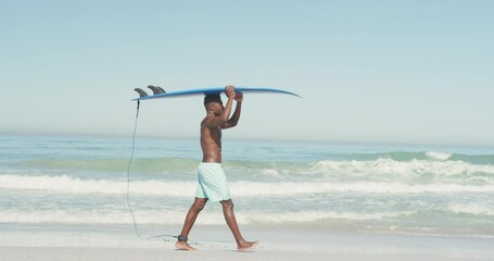 African American man holding a surfboard on his head