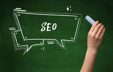 Hand drawing SEO abbreviation with white chalk on blackboard