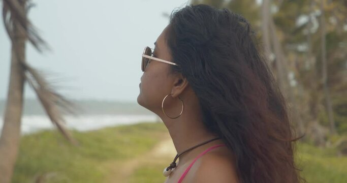 Prettty Trinidadian model with hoop earings enjoying the sea breeze