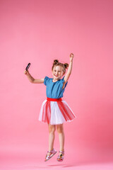 funny laughing baby girl jumping on pink background.