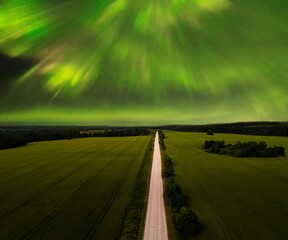 Northern Lights - Aurora borealis over the road and field