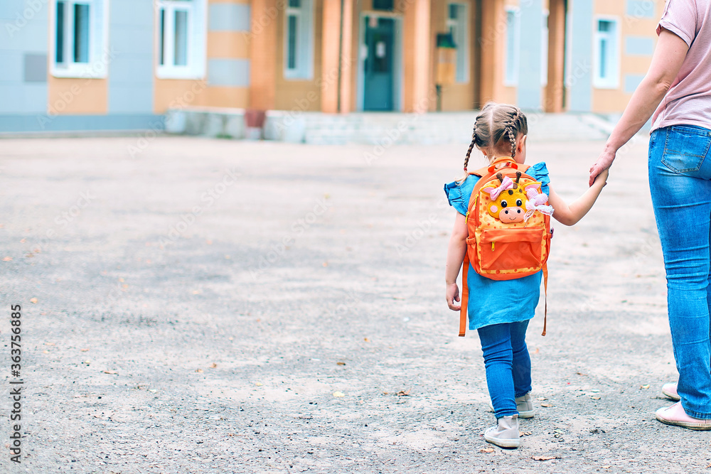 Wall mural mother accompanies to school and supports her daughter morally, holding hands.