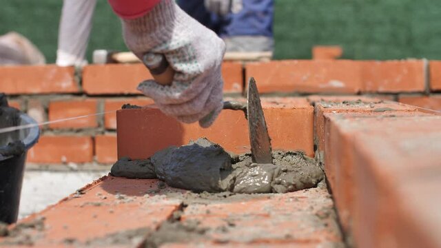 Industrial Bricklayers Installing Brick on Construction Site
