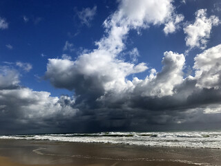 Australian beach with storm clouds and reflections in the sand, Mudjimba Beach, Queensland