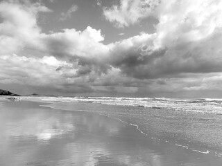 Australian beach with storm clouds and reflections in the sand, Mudjimba Beach, Queensland