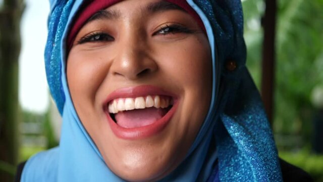 Portrait of professional young muslim business woman looking at camera laughing happy wearing traditional headscarf