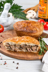 Oven cooked meat pie served on a round wooden board