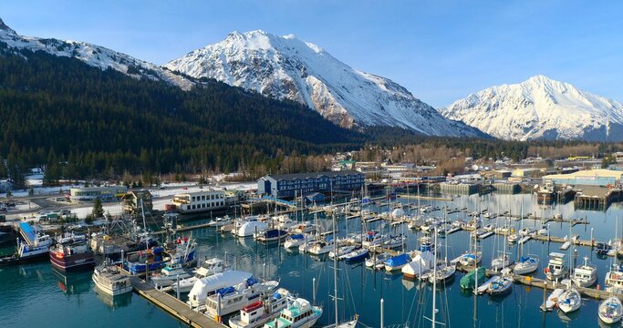 Sailboats Moored In Harbor By Mountains Against Sky