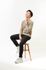 Full body Asian man sitting on high chair over white background