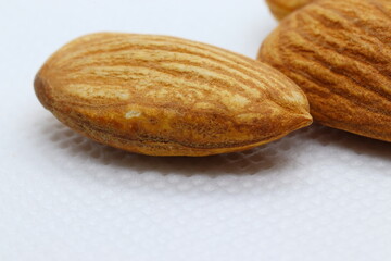 close up of almond seeds with white background