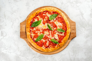 Pizza with sausage and herbs on a wooden board