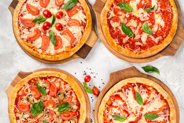 Four types of pizza shot from above on wooden boards