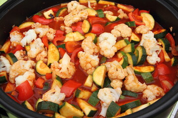 a pan with cauliflower, zucchini, peppers and tomato