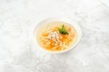 Chicken soup in a white, round plate shot from above