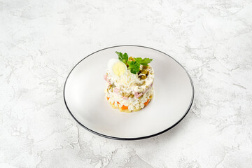 Olivier salad on a white, round plate. Close-up shot