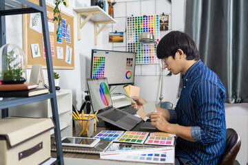 Asian men Architect or graphic designer designing a layout selection swatch samples for coloring screen
