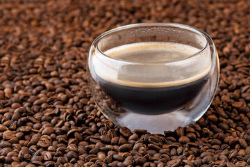 Cup of hot coffee on coffee beans background