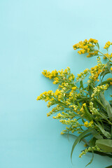 Bouquet of yellow wildflowers on a green light vertical background.