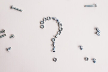 Question mark lined with bolts and nuts on a white background. Question mark made of metal.