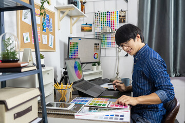 Asian men Architect or graphic designer designing a layout selection swatch samples for coloring screen

