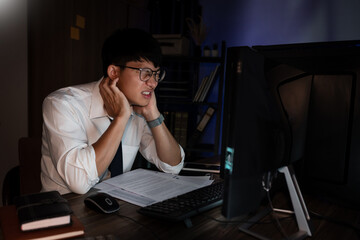 Asian businessman concentrated working until late overtime in office at night
