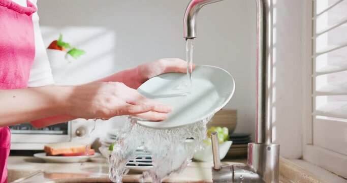 Asian housewife wash dishes