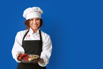 Female African-American chef with tasty dish on color background
