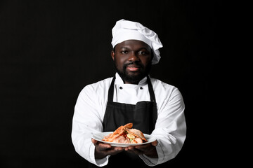 Male African-American chef with tasty dish on dark background