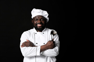 Naklejka premium Male African-American chef on dark background