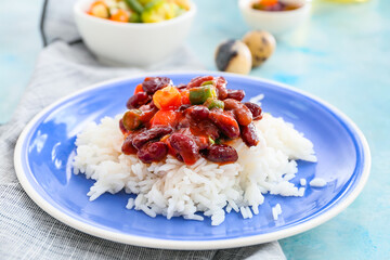 Plate with tasty rice, beans and vegetables on color background