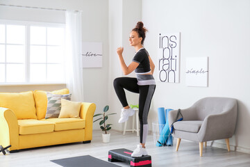 Sporty young woman training at home